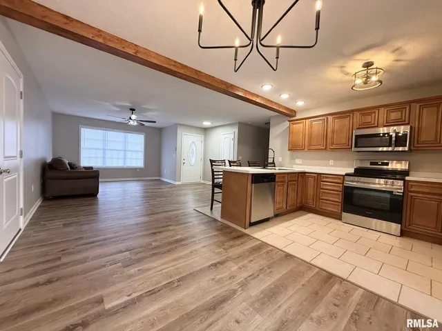 a kitchen with stainless steel appliances kitchen island granite countertop a stove a refrigerator and a microwave oven with cabinets