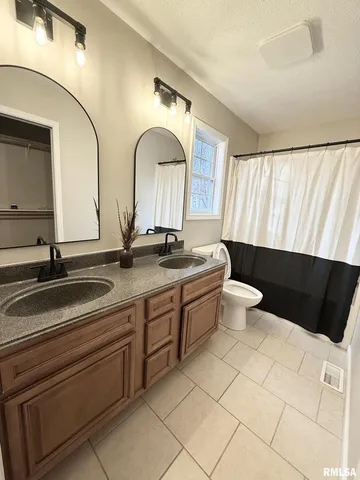 a spacious bathroom with a double vanity sink a mirror and a