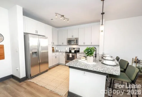 a kitchen with granite countertop a counter space stainless steel appliances and cabinets