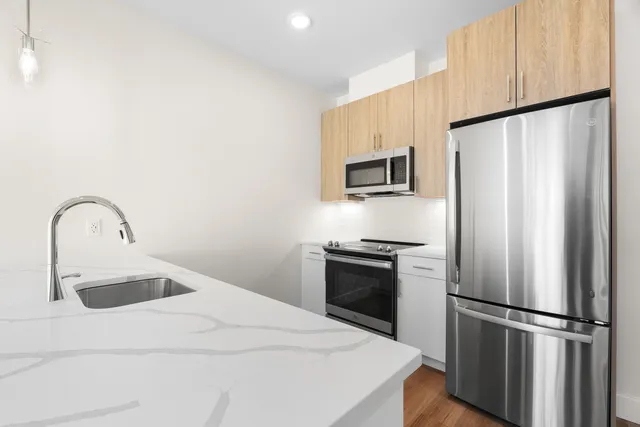 a kitchen with stainless steel appliances a refrigerator sink and microwave