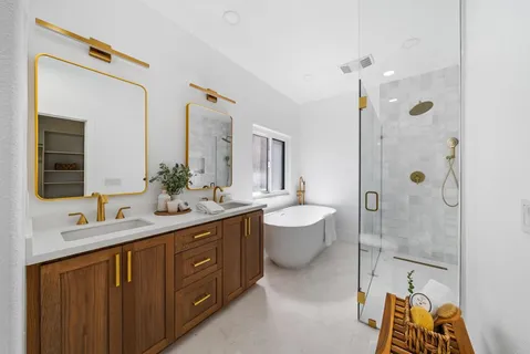 a spacious bathroom with a double vanity sink mirror and bathtub