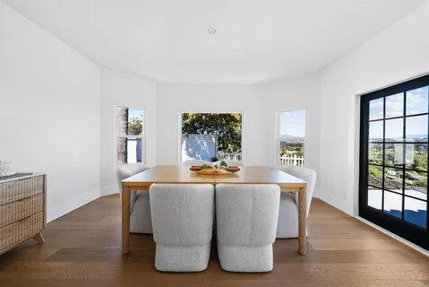 a living room with large window and wooden floor