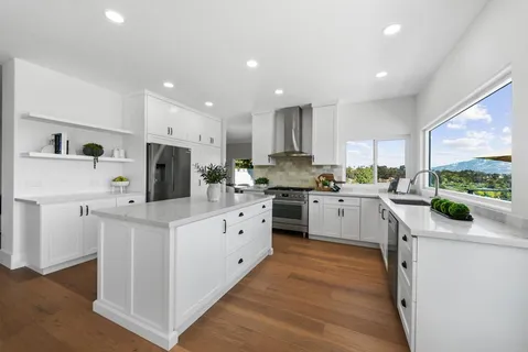 a kitchen with white cabinets and stainless steel appliances