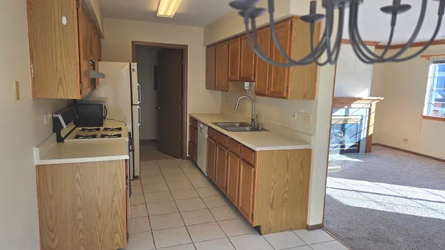 a kitchen with kitchen island granite countertop a sink a counter top space cabinets stainless steel appliances and a window