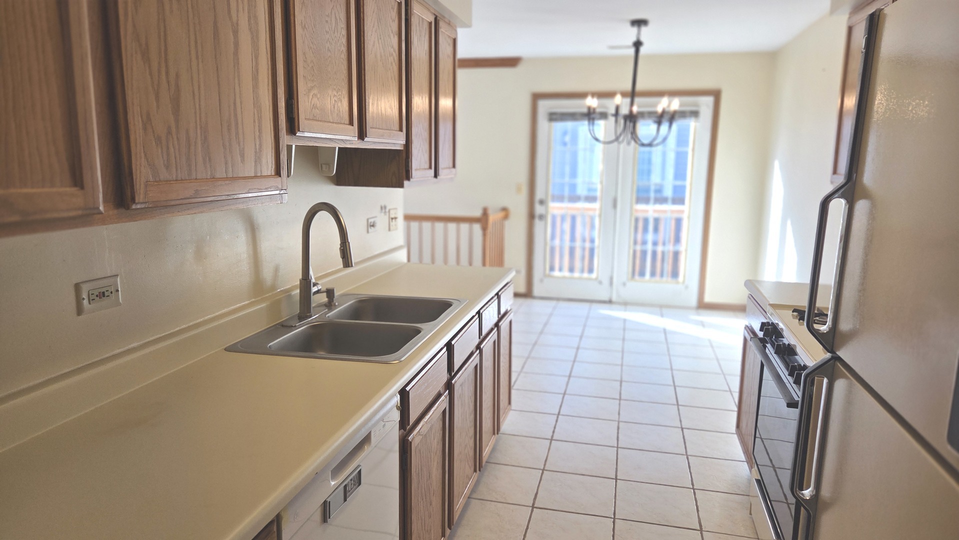 427 Village Creek Drive Lake In The Hills, IL 60156 - Photo 7 of 11 a kitchen with kitchen island granite countertop a sink a counter top space cabinets stainless steel appliances and a window