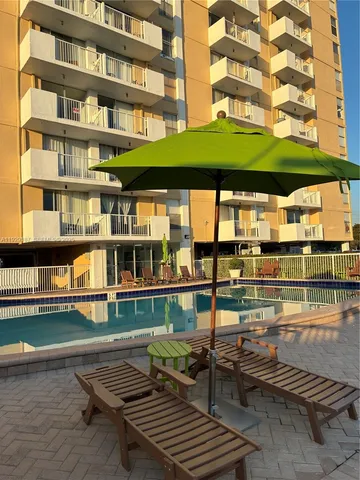 a roof deck with table and chairs and a floor to ceiling window