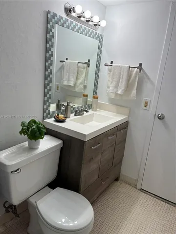 a bathroom with a sink a toilet a mirror and shower curtain