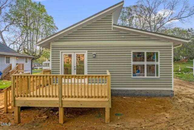 a view of a house with a small yard and wooden fence