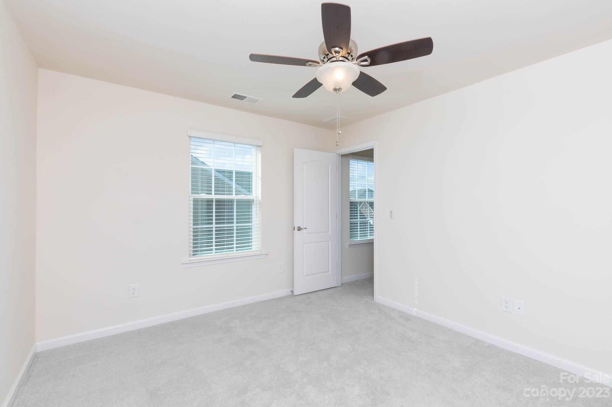 1609 Tranquility Boulevard Lancaster, SC 29720 - Photo 21 of 35 an empty room with ceiling fan and windows