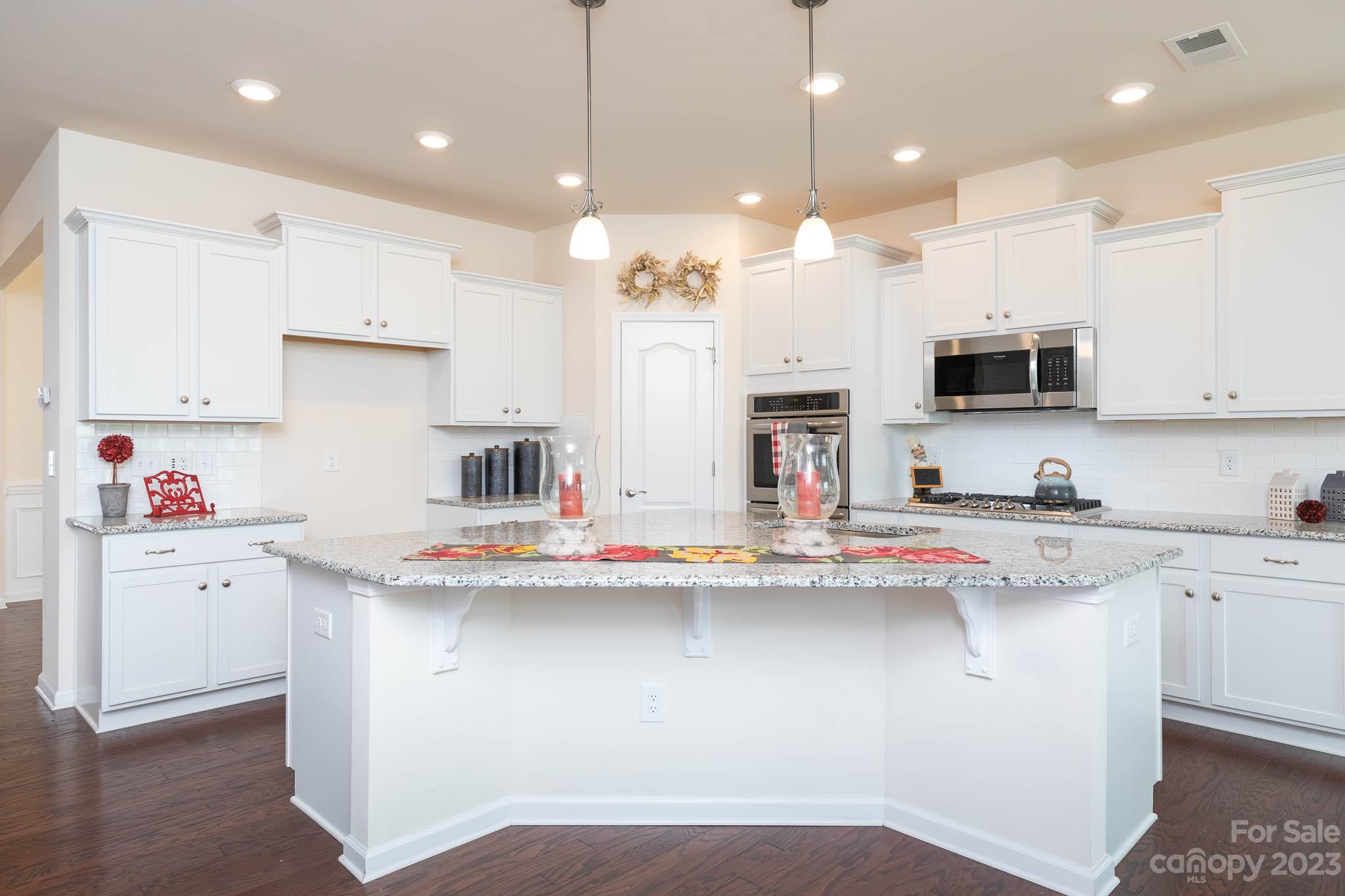 1609 Tranquility Boulevard Lancaster, SC 29720 - Photo 5 of 35 a kitchen with stainless steel appliances granite countertop a sink and white cabinets