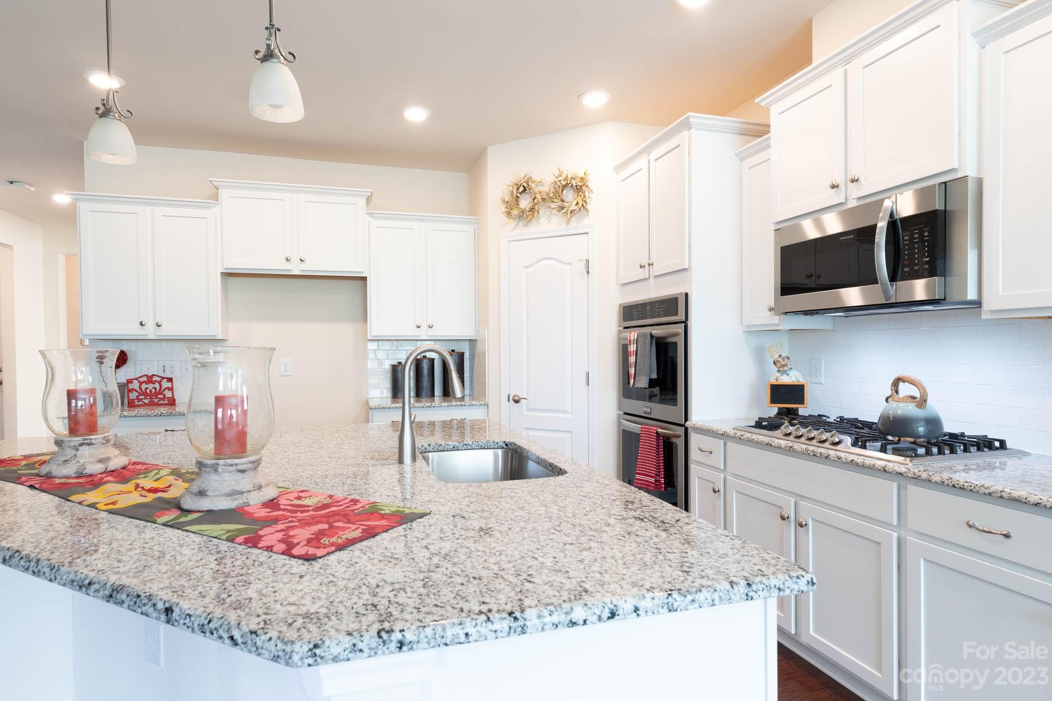 1609 Tranquility Boulevard Lancaster, SC 29720 - Photo 6 of 35 a kitchen with stainless steel appliances granite countertop a sink stove and refrigerator