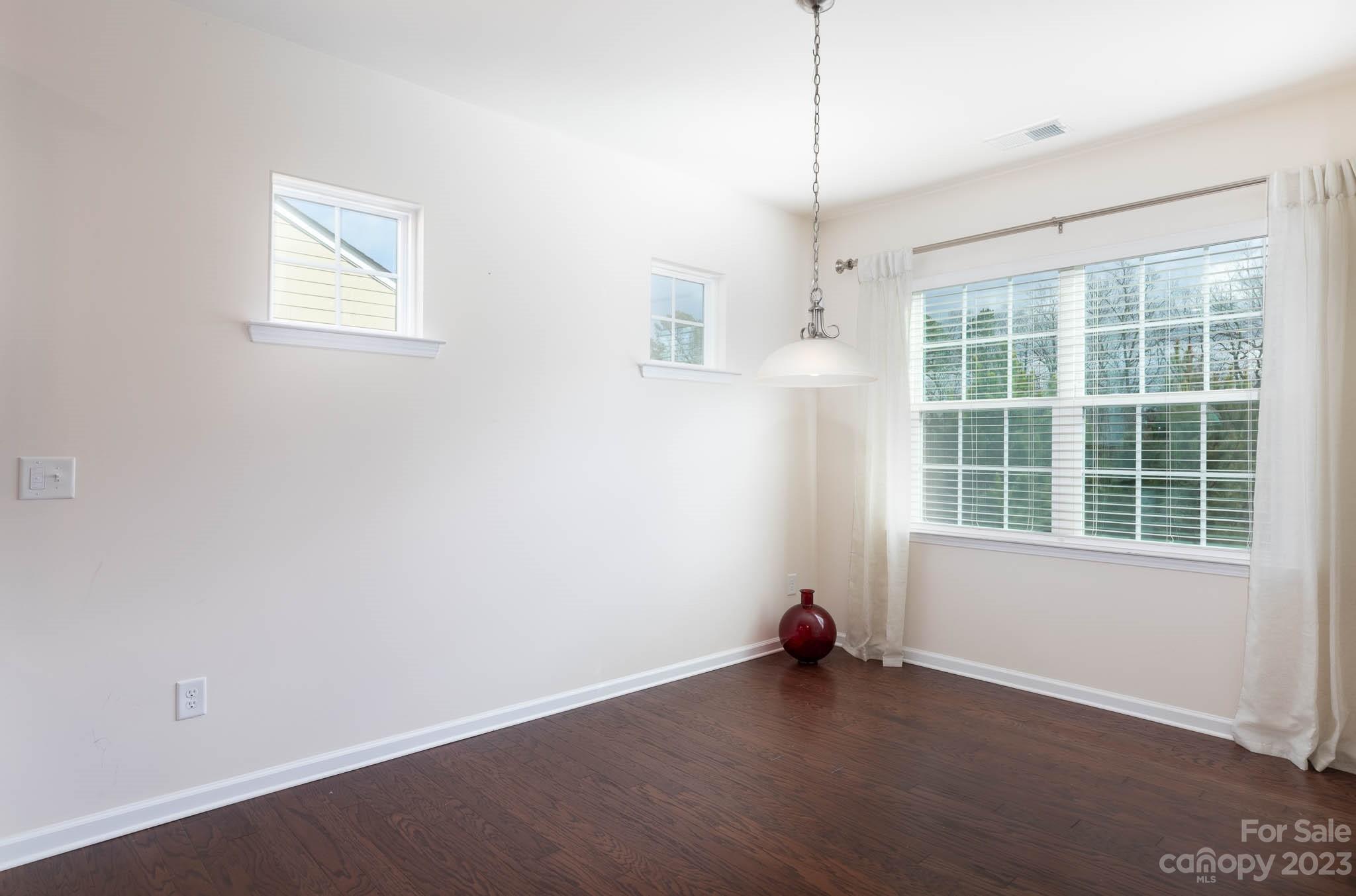 1609 Tranquility Boulevard Lancaster, SC 29720 - Photo 9 of 35 an empty room with wooden floor and windows