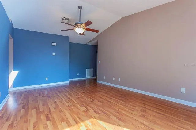 a view of an empty room with wooden floor