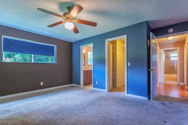 a view of an empty room with a ceiling fan and a window