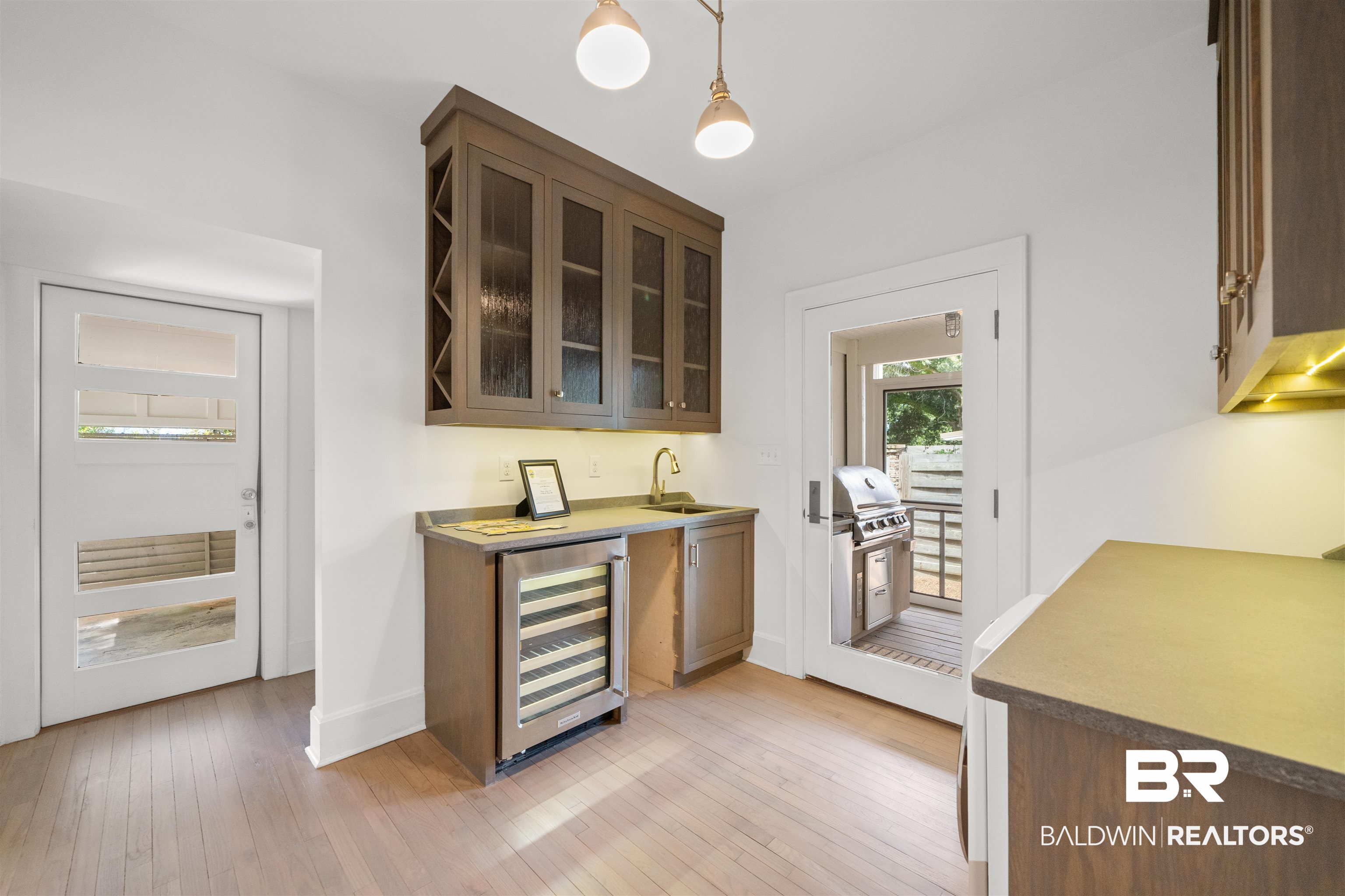 106 White Avenue Fairhope, AL 36532 - Photo 10 of 35 Indoor wet bar featuring wine cooler, light wood-type flooring, and pendant lighting
