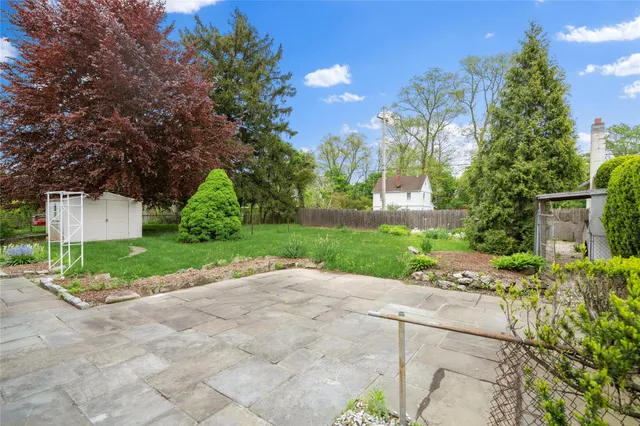 a view of a house with a yard and a large tree