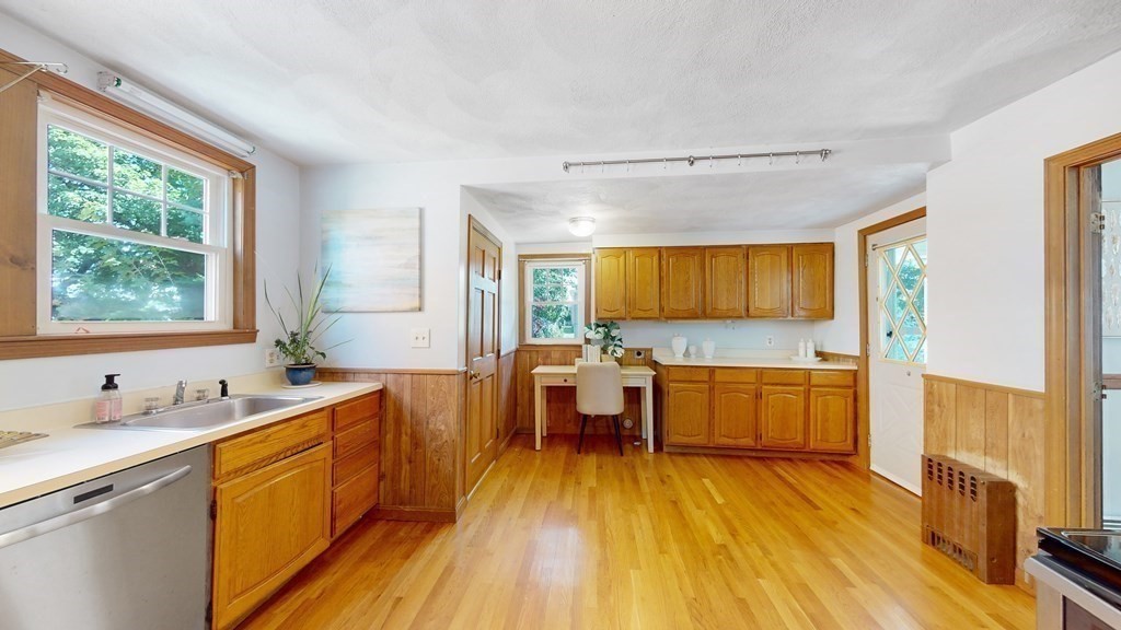 82 Roberts Road Medford, MA 02155 - Photo 8 of 30 a large kitchen with a wooden floor and cabinets