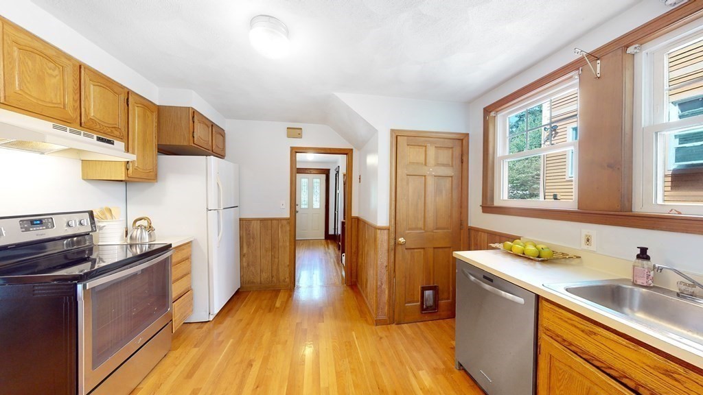 82 Roberts Road Medford, MA 02155 - Photo 9 of 30 a kitchen with granite countertop a sink and wooden cabinets