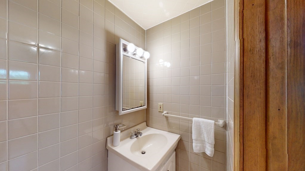 82 Roberts Road Medford, MA 02155 - Photo 10 of 30 a bathroom with a sink a toilet and mirror