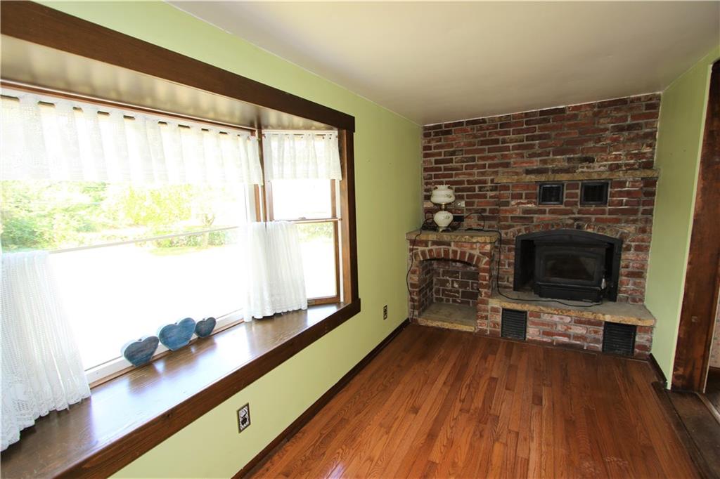453 Simpson Howell Road Elizabeth, PA 15037 - Photo 13 of 25 Family Room has Wood Burner Stove with a Brick Accent Wall, Mantle, and Wood Storage Area.