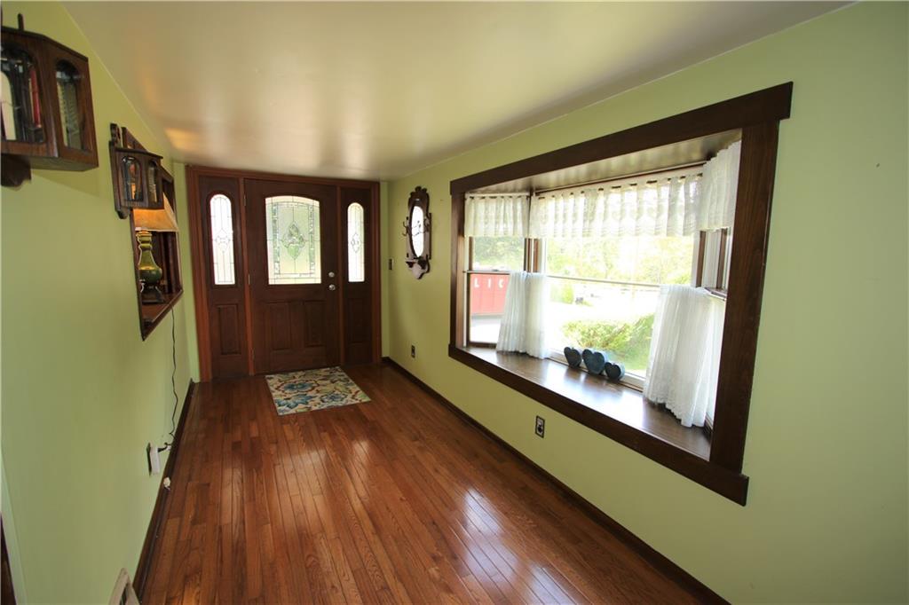 453 Simpson Howell Road Elizabeth, PA 15037 - Photo 4 of 25 18x7 Family Room has a Beautiful Newer Front Door with Decorative Lead Glass Inset and Side Lite Details. Wooden Bay Window, Hardwood Flooring, and Interior Window with Wooden Privacy Shutters.