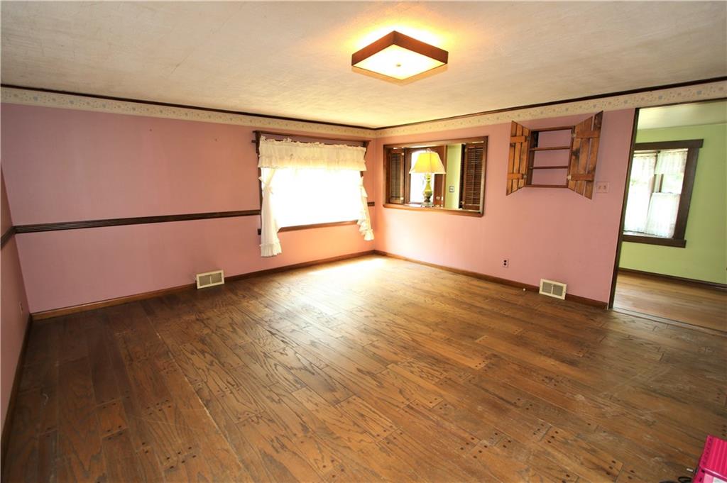 453 Simpson Howell Road Elizabeth, PA 15037 - Photo 6 of 25 16x15 Large Living Room with Hardwood Floors, Wooden Chair Rail, and Baseboard Details & Crown Molding Details.