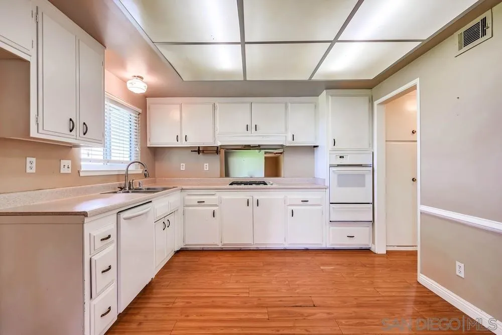 5970 Eucalyptus Drive Highland, CA 92346 - Photo 11 of 26 a kitchen with stainless steel appliances granite countertop a sink and cabinets with wooden floor