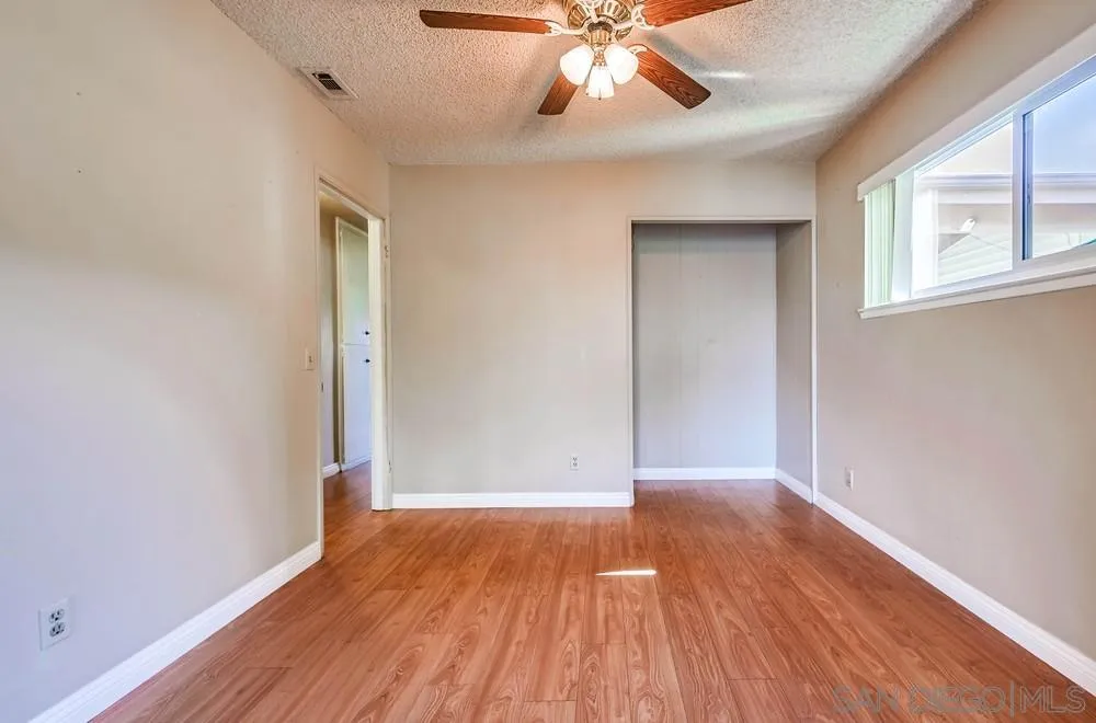 5970 Eucalyptus Drive Highland, CA 92346 - Photo 12 of 26 an empty room with wooden floor and windows