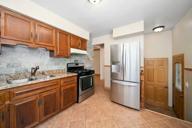 a kitchen with stainless steel appliances granite countertop a refrigerator stove a sink and dishwasher