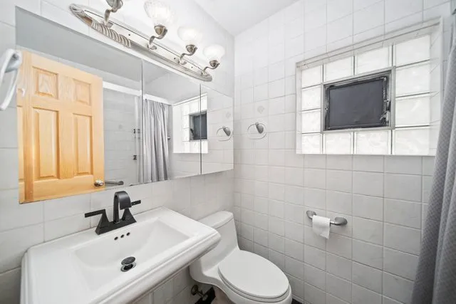 a bathroom with a sink a toilet and mirror