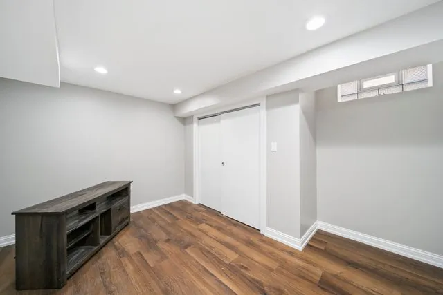 a view of kitchen and empty room with wooden floor