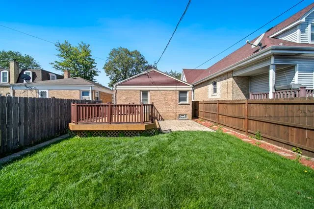 a view of a house with a small yard and wooden fence