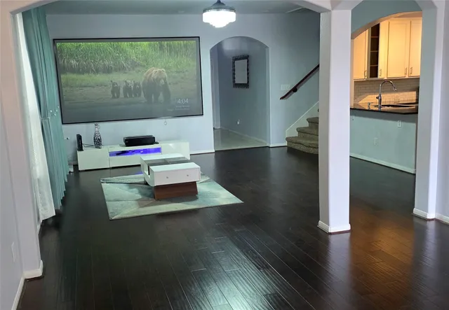 a living room with dining room and wooden floor