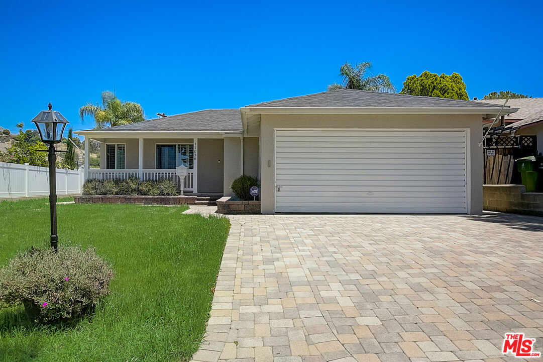 a front view of a house with a garden and yard