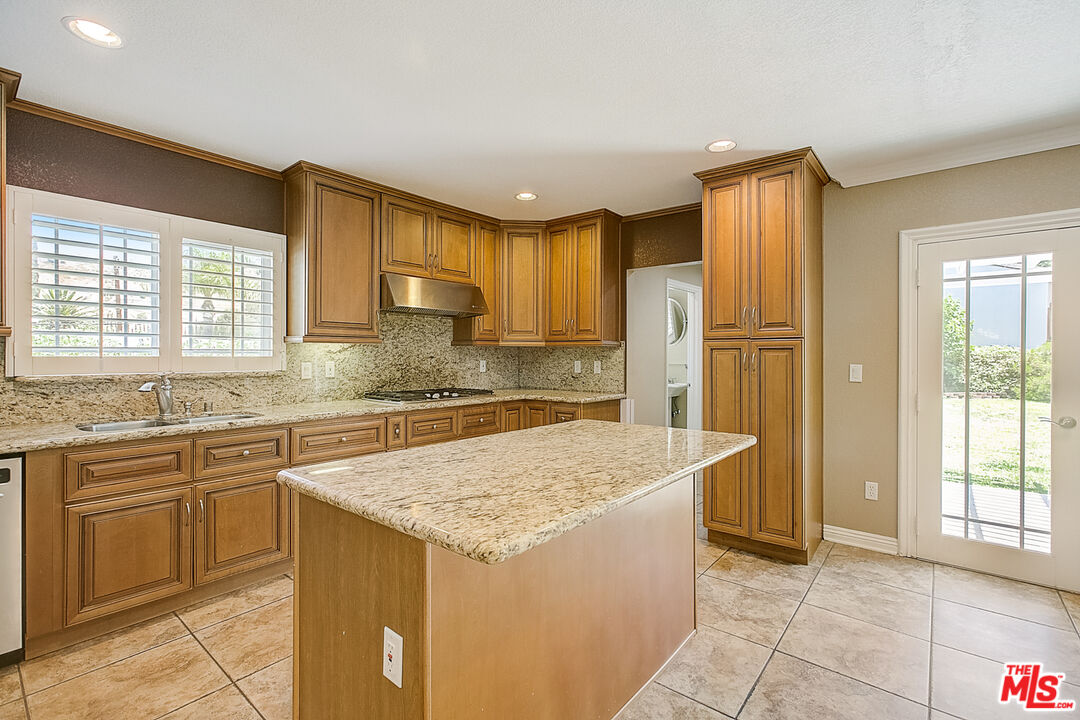 11038 Rhodesia Avenue Sunland, CA 91040 - Photo 14 of 36 a kitchen with granite countertop a sink stove and refrigerator