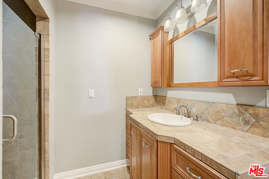 11038 Rhodesia Avenue Sunland, CA 91040 - Photo 24 of 36 a bathroom with a granite countertop sink and a mirror