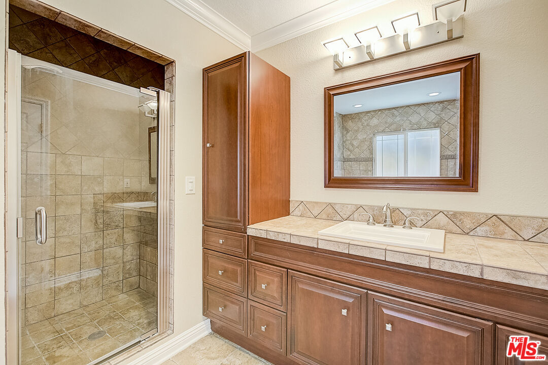 11038 Rhodesia Avenue Sunland, CA 91040 - Photo 7 of 36 a bathroom with a sink a mirror and a shower