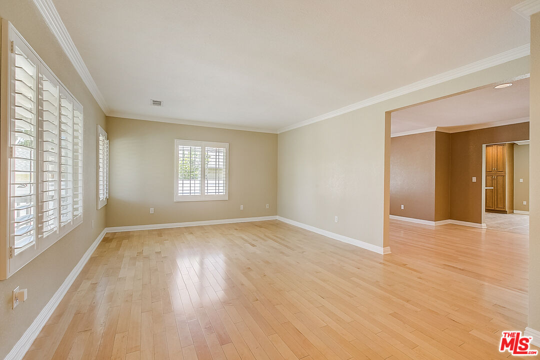 11038 Rhodesia Avenue Sunland, CA 91040 - Photo 10 of 36 a view of an empty room with glass door and wooden floor