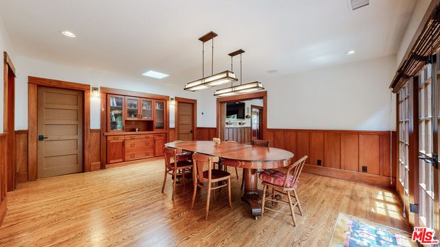 a large kitchen with stainless steel appliances granite countertop a large stove top oven a sink dishwasher and wooden cabinets with wooden floor