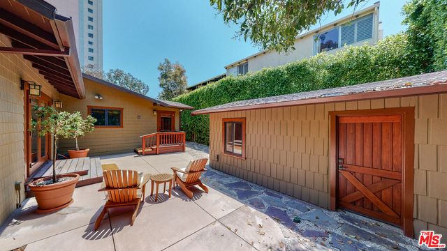 a view of a chair and table in backyard of the house