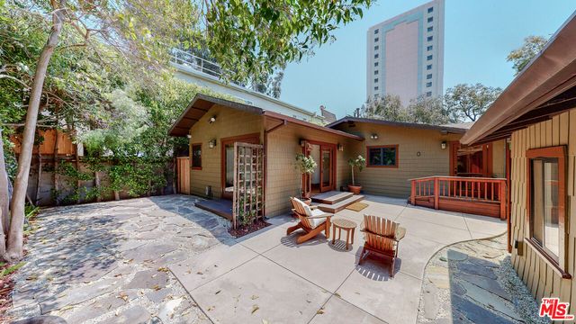 a view of a house with a yard and furniture