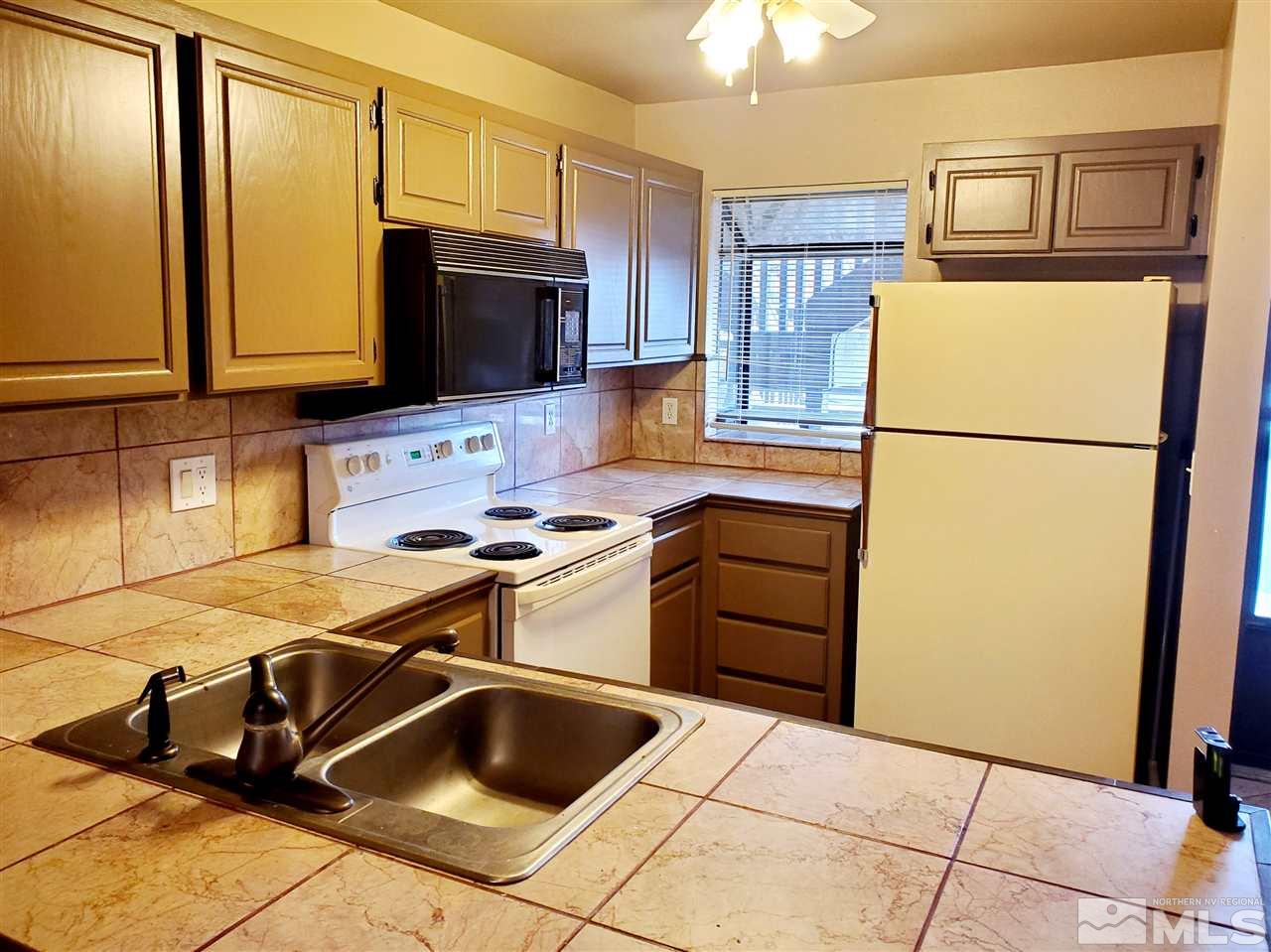 2929 Tierra Verde East Reno, NV 89512 - Photo 5 of 10 a kitchen with stainless steel appliances granite countertop a refrigerator stove and sink