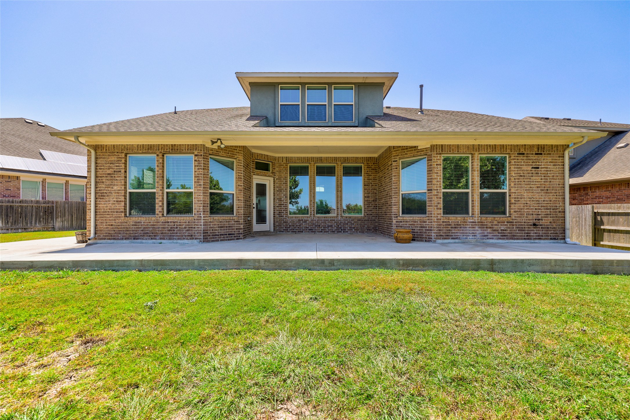 409 Betony Loop Buda, TX 78610 - Photo 27 of 38 A well-maintained lawn and concrete patio provide ample outdoor space for relaxation or entertaining.