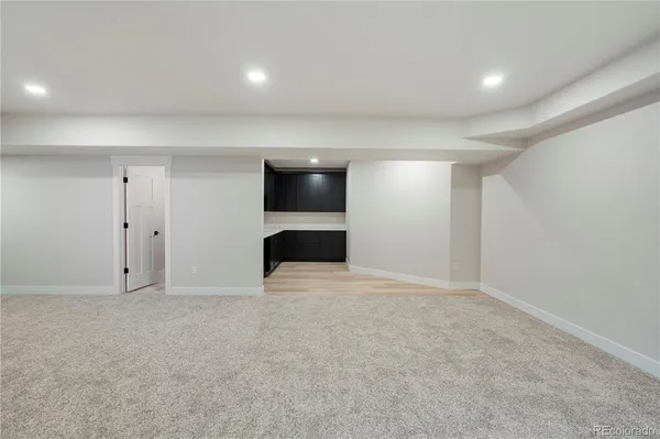 an empty room with kitchen and stairs