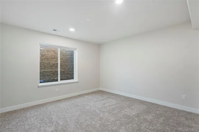 an empty room with closet and windows