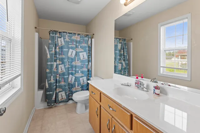 a bathroom with a sink vanity mirror and toilet