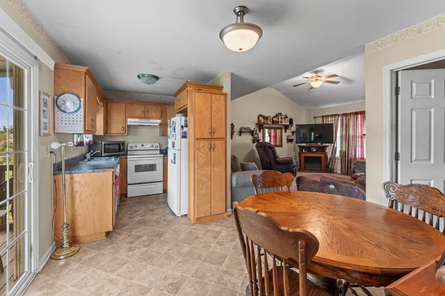 a kitchen with stainless steel appliances granite countertop a refrigerator a stove top oven a sink dishwasher and white cabinets