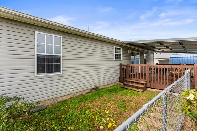 a view of a house with wooden deck and a yard