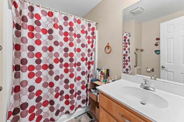 a bathroom with a sink a mirror a vanity and a shower curtain
