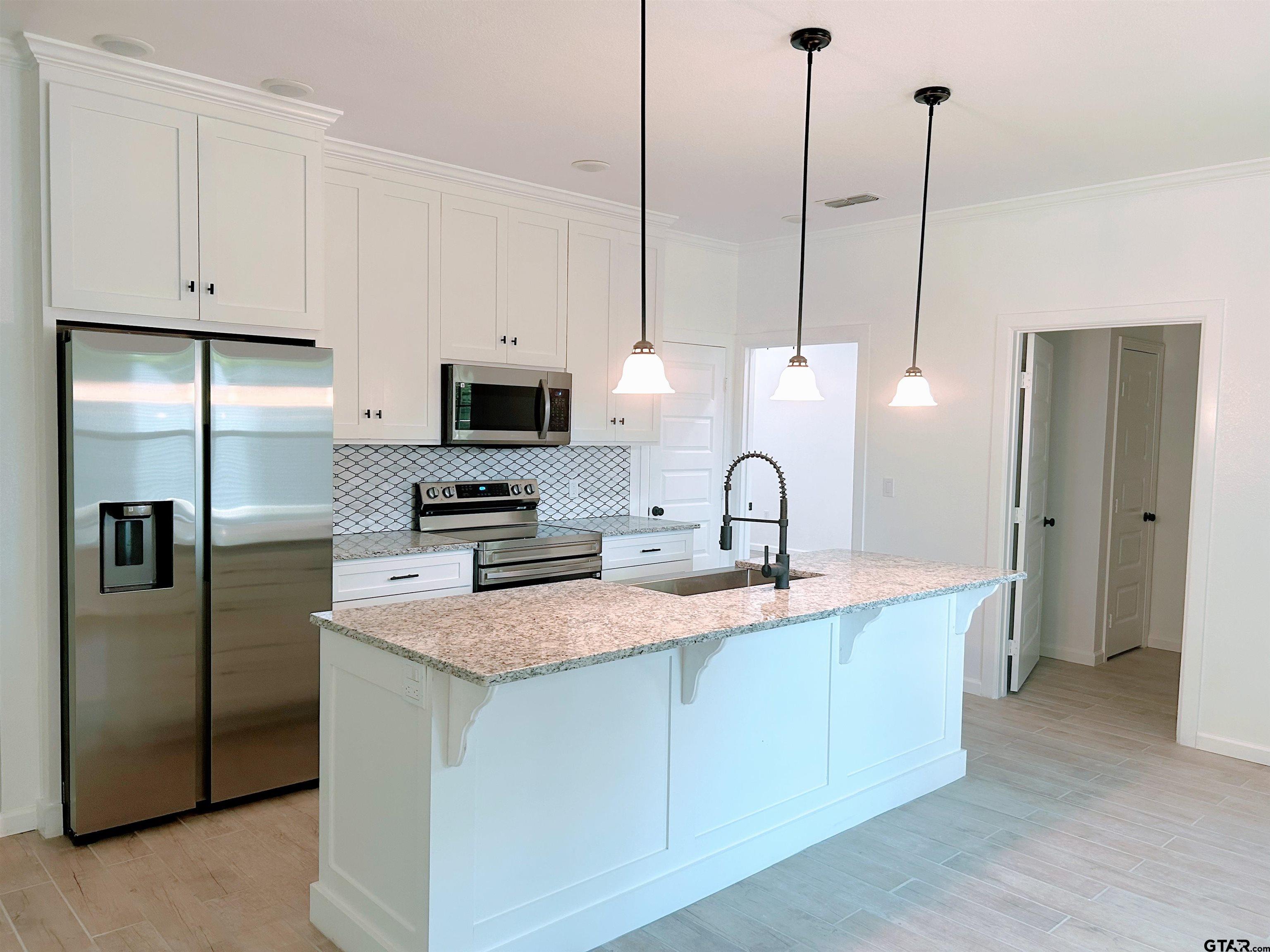 20428 High Point Drive Flint, TX 75762 - Photo 6 of 18 a kitchen with stainless steel appliances granite countertop a sink a stove a refrigerator a center island and cabinets